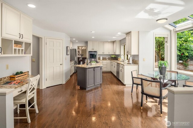 2778 142nd Pl NE, Bellevue, WA 98007 - kitchen featuring appliances with stainless steel finishes, dark wood finished floors, a center island, recessed lighting, and a skylight