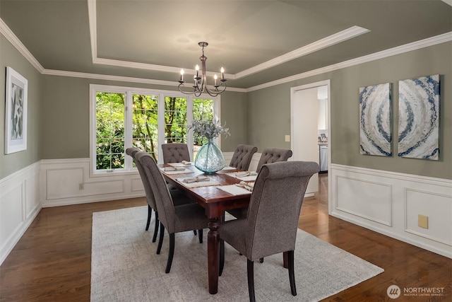 2778 142nd Pl NE, Bellevue, WA 98007 - dining room featuring a tray ceiling, dark wood-style floors, a chandelier, ornamental molding, and wainscoting