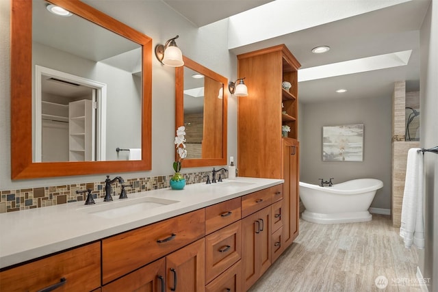 2778 142nd Pl NE, Bellevue, WA 98007 - full bath with double vanity, wood finished floors, a freestanding bath, backsplash, and recessed lighting