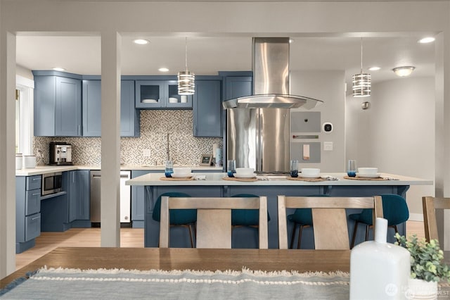 5113 212th St SW, Lynnwood, WA 98036 - kitchen featuring wall chimney exhaust hood, appliances with stainless steel finishes, blue cabinets, tasteful backsplash, and recessed lighting
