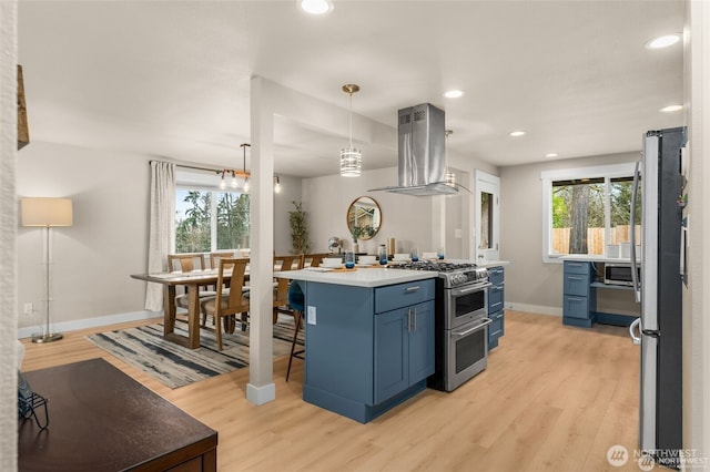 5113 212th St SW, Lynnwood, WA 98036 - kitchen with stainless steel appliances, island exhaust hood, blue cabinets, light wood-style flooring, and recessed lighting