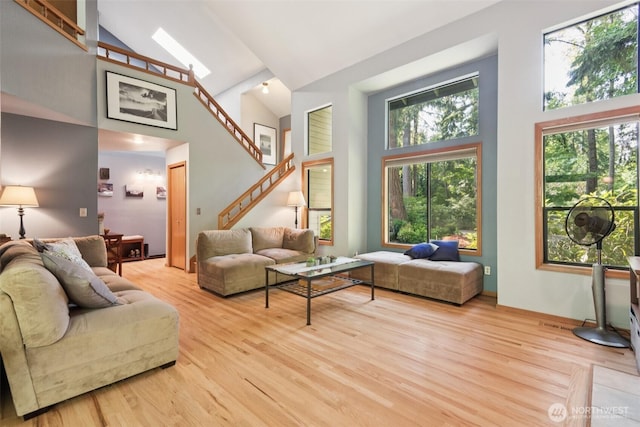 24230 218th Ave SE, Maple Valley, WA 98038 - living room with high vaulted ceiling, stairs, and light wood-style floors