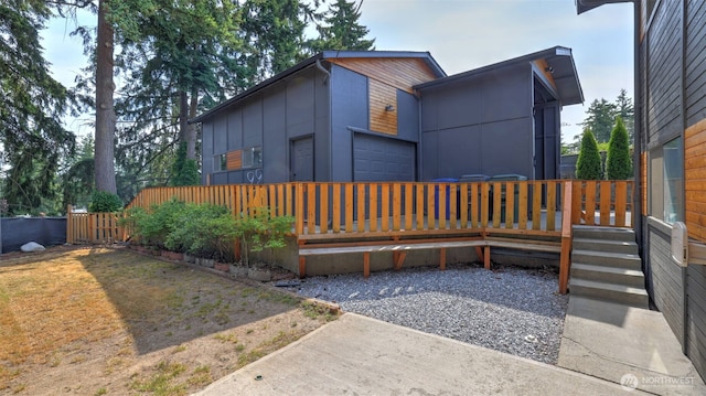 501 143rd St S, Tacoma, WA 98444 - modern home featuring a garage, a wooden deck, and board and batten siding