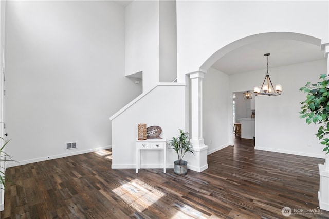 1611 Austin Ave, Snohomish, WA 98290 - empty room featuring dark wood-style floors, arched walkways, a chandelier, and decorative columns