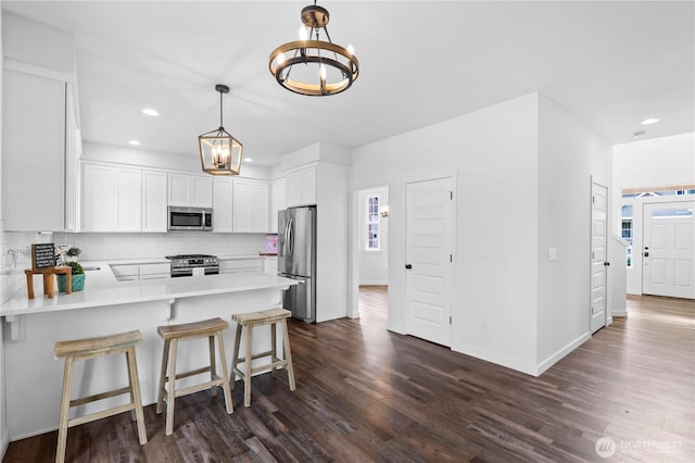 1611 Austin Ave, Snohomish, WA 98290 - kitchen featuring appliances with stainless steel finishes, a chandelier, dark wood finished floors, backsplash, and a peninsula