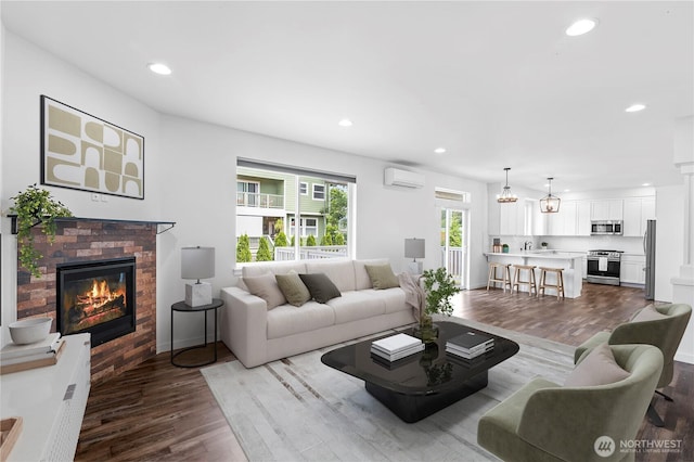1611 Austin Ave, Snohomish, WA 98290 - living room featuring a wall mounted AC, wood finished floors, a fireplace, and recessed lighting