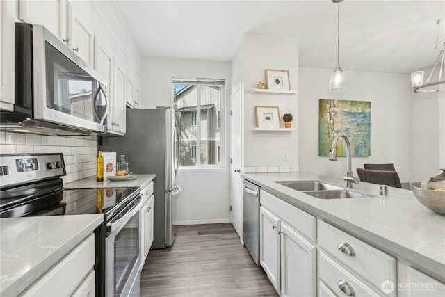 3006 SE 8th St Unit 2120, Renton, WA 98058 - kitchen featuring appliances with stainless steel finishes, wood finished floors, white cabinetry, decorative backsplash, and light countertops