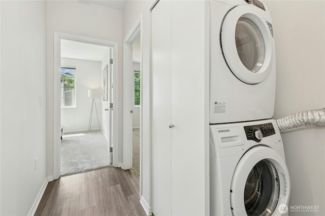 3006 SE 8th St Unit 2120, Renton, WA 98058 - washroom featuring stacked washer and clothes dryer and wood finished floors