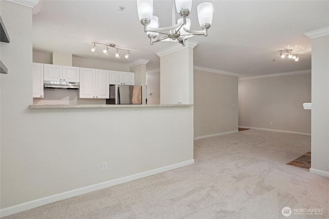 33020 10th Ave SW Unit E204, Federal Way, WA 98023 - kitchen with freestanding refrigerator, under cabinet range hood, carpet flooring, crown molding, and white cabinets