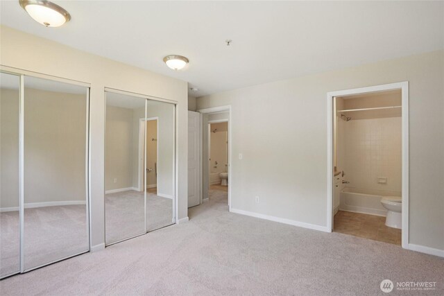 33020 10th Ave SW Unit E204, Federal Way, WA 98023 - unfurnished bedroom with multiple closets, carpet floors, and ensuite bathroom