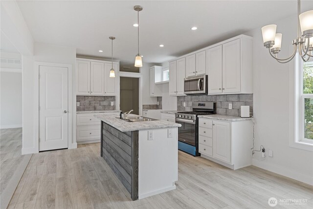 2204 Dublin Pl, Anacortes, WA 98221 - kitchen featuring appliances with stainless steel finishes, tasteful backsplash, white cabinetry, light wood-type flooring, and recessed lighting