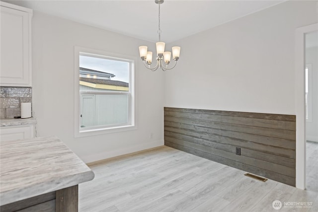 2204 Dublin Pl, Anacortes, WA 98221 - unfurnished dining area with a chandelier and light wood-style flooring