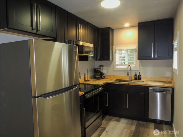 14806 131st Ave SE, Renton, WA 98058 - kitchen with appliances with stainless steel finishes, butcher block counters, light wood finished floors, and dark cabinets