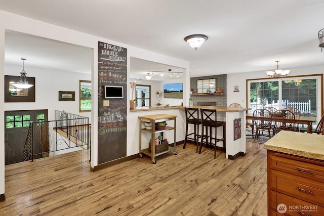 2815 Willis St, Bellingham, WA 98225 - kitchen featuring a chandelier, light wood-style flooring, track lighting, a kitchen breakfast bar, and pendant lighting