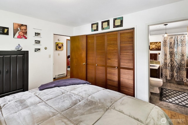 2815 Willis St, Bellingham, WA 98225 - bedroom featuring baseboard heating, a closet, connected bathroom, and wood finished floors
