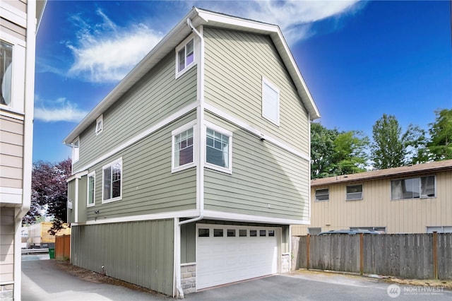 10736 Whitman Ave N, Seattle, WA 98133 - view of home's exterior with stone siding, a garage, and driveway