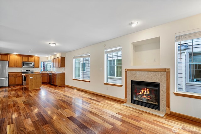 10736 Whitman Ave N, Seattle, WA 98133 - kitchen featuring stainless steel appliances, open floor plan, brown cabinets, wood finished floors, and light countertops