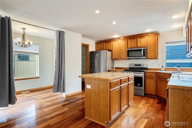 10736 Whitman Ave N, Seattle, WA 98133 - kitchen featuring stainless steel appliances, a center island, light wood finished floors, a chandelier, and recessed lighting