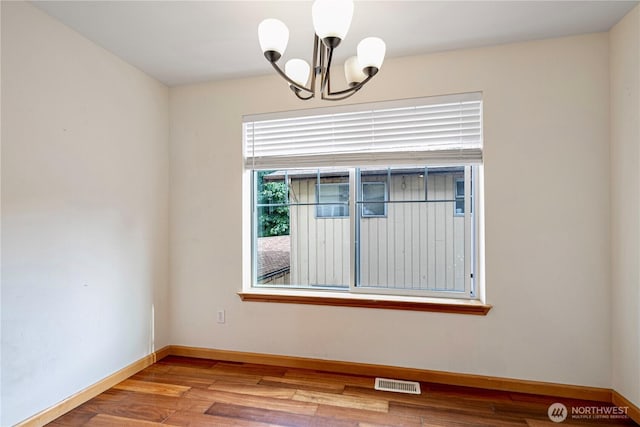 10736 Whitman Ave N, Seattle, WA 98133 - unfurnished room with a chandelier and wood finished floors