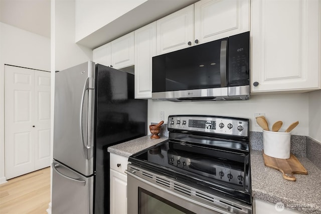 122 S State St Unit 207E, Kirkland, WA 98033 - kitchen with appliances with stainless steel finishes, white cabinets, light wood-style floors, and light countertops