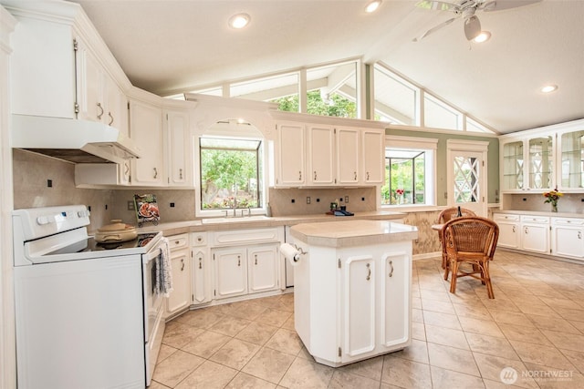2130 W 4th, Port Angeles, WA 98363 - kitchen featuring white electric stove, under cabinet range hood, healthy amount of natural light, light tile patterned floors, and recessed lighting