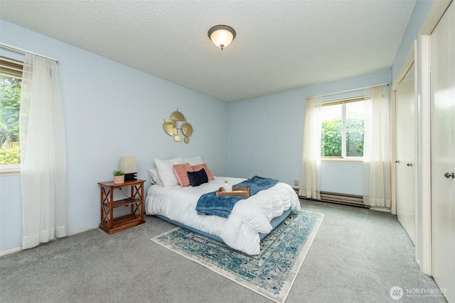 2130 W 4th, Port Angeles, WA 98363 - bedroom with carpet, a baseboard radiator, and a textured ceiling
