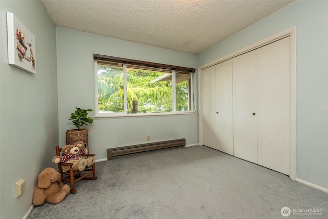 2130 W 4th, Port Angeles, WA 98363 - unfurnished bedroom featuring baseboard heating, carpet flooring, a textured ceiling, and a closet