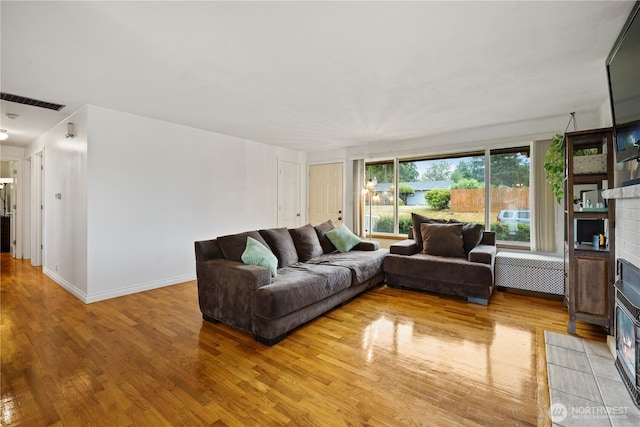 1220 S 313th St, Federal Way, WA 98003 - living area with radiator, a fireplace with flush hearth, and light wood-style flooring