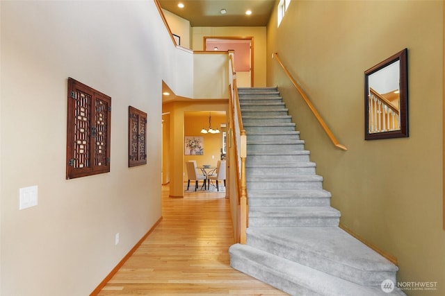 18328 10th Dr SE, Bothell, WA 98012 - stairs with wood finished floors, a towering ceiling, a chandelier, and recessed lighting