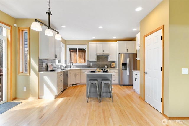 18328 10th Dr SE, Bothell, WA 98012 - kitchen with appliances with stainless steel finishes, decorative backsplash, a kitchen island, light countertops, and recessed lighting