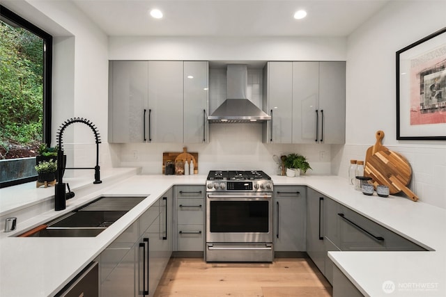 5606 23rd Ave SW, Seattle, WA 98106 - kitchen featuring appliances with stainless steel finishes, gray cabinetry, wall chimney range hood, modern cabinets, and recessed lighting