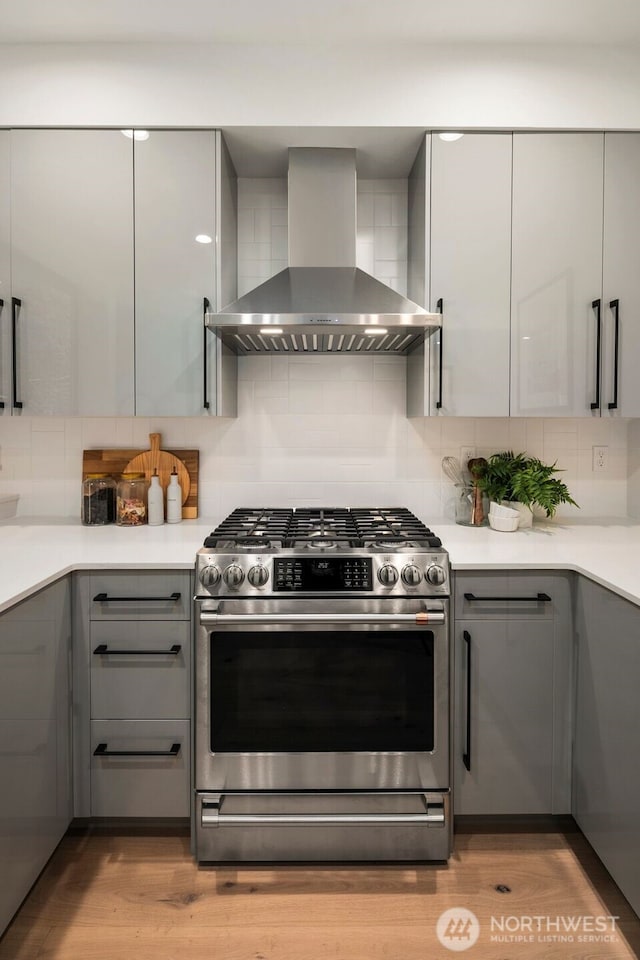 5606 23rd Ave SW, Seattle, WA 98106 - kitchen with stainless steel gas range oven, wall chimney exhaust hood, gray cabinets, and backsplash