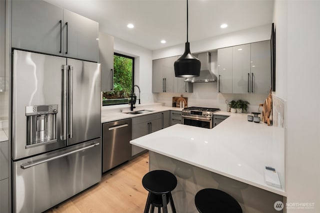 5606 23rd Ave SW, Seattle, WA 98106 - kitchen featuring appliances with stainless steel finishes, gray cabinetry, a peninsula, a kitchen bar, and backsplash
