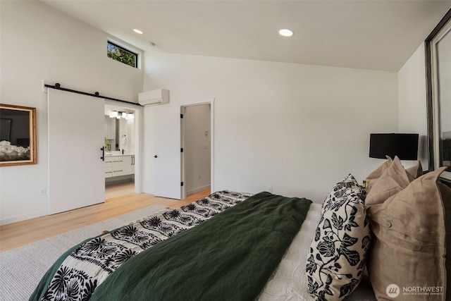 5606 23rd Ave SW, Seattle, WA 98106 - bedroom with light wood-type flooring, a barn door, high vaulted ceiling, recessed lighting, and ensuite bathroom