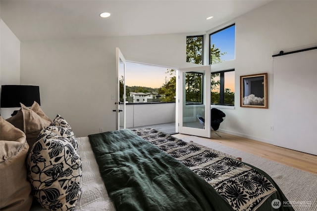 5606 23rd Ave SW, Seattle, WA 98106 - bedroom with wood finished floors, a barn door, recessed lighting, and a towering ceiling