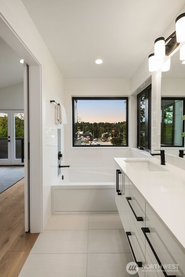 5606 23rd Ave SW, Seattle, WA 98106 - full bathroom featuring vanity, a bath, recessed lighting, wood finished floors, and french doors