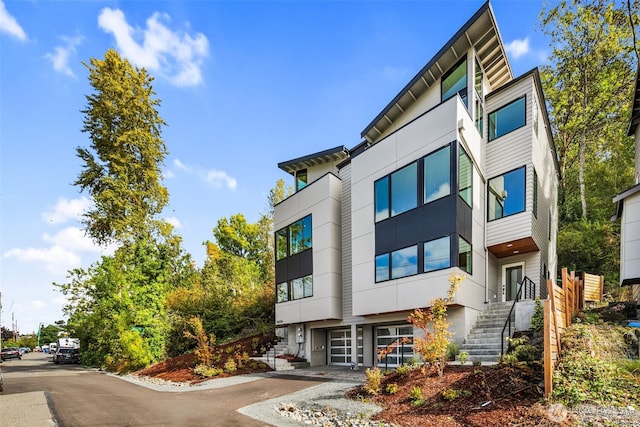 5606 23rd Ave SW, Seattle, WA 98106 - view of property with a garage, asphalt driveway, and stairway