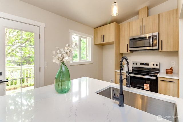 21241 S 29th Ave, Seatac, WA 98198 - kitchen with stainless steel microwave, electric range, light brown cabinets, hanging light fixtures, and light stone countertops