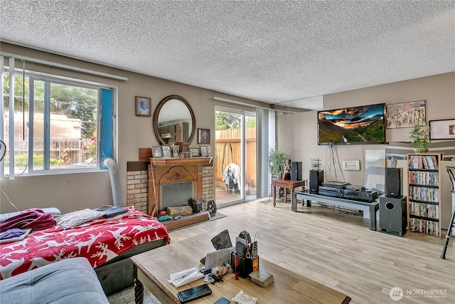 1823 M St NE Unit 1823, Auburn, WA 98002 - living area featuring a textured ceiling, wood finished floors, and a brick fireplace