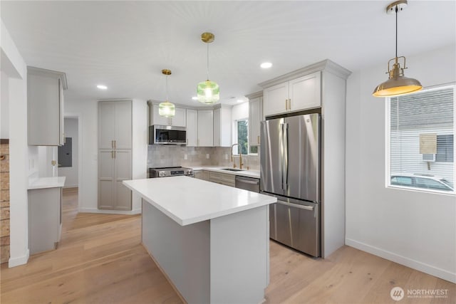 10303 40th Ave E, Tacoma, WA 98446 - kitchen with appliances with stainless steel finishes, decorative backsplash, light wood finished floors, light countertops, and a center island