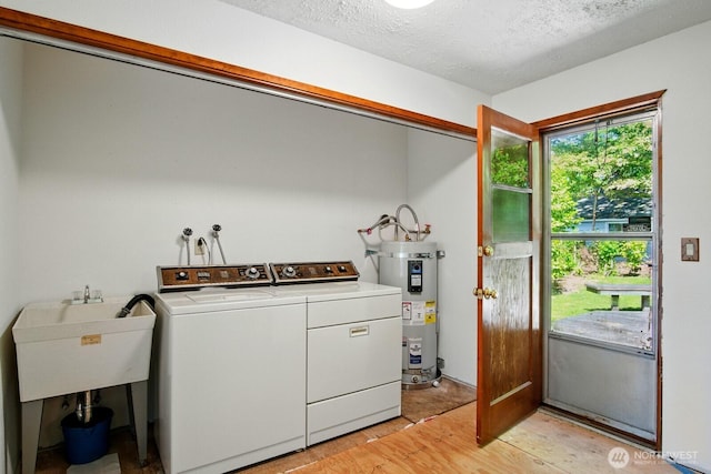 10022 8th Ave NE, Seattle, WA 98125 - washroom featuring strapped water heater, washing machine and dryer, light wood finished floors, and a textured ceiling