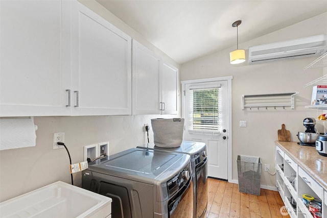 3288 NW Happy Hollow Ln, Silverdale, WA 98383 - laundry room featuring cabinet space, separate washer and dryer, an AC wall unit, and light wood-style floors