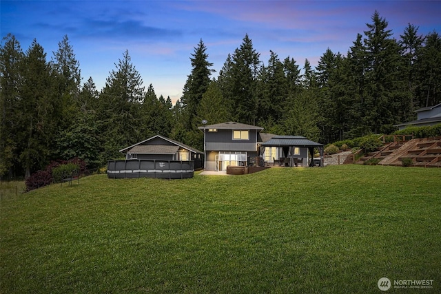 3288 NW Happy Hollow Ln, Silverdale, WA 98383 - back of property at dusk featuring a gazebo, an outdoor pool, and a lawn