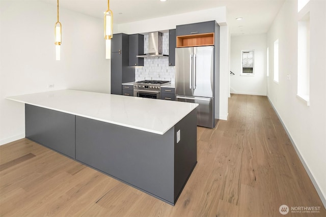 1244 15th Ave E Unit 9, Seattle, WA 98112 - kitchen featuring appliances with stainless steel finishes, wall chimney range hood, a peninsula, decorative backsplash, and light countertops