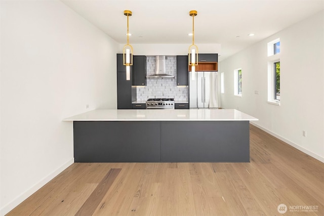 1244 15th Ave E Unit 9, Seattle, WA 98112 - kitchen featuring wall chimney range hood, stainless steel appliances, a peninsula, light countertops, and backsplash