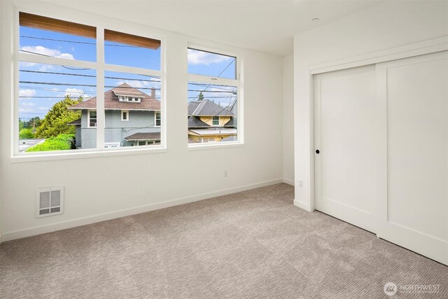 1244 15th Ave E Unit 9, Seattle, WA 98112 - unfurnished bedroom featuring multiple windows, light colored carpet, and a closet