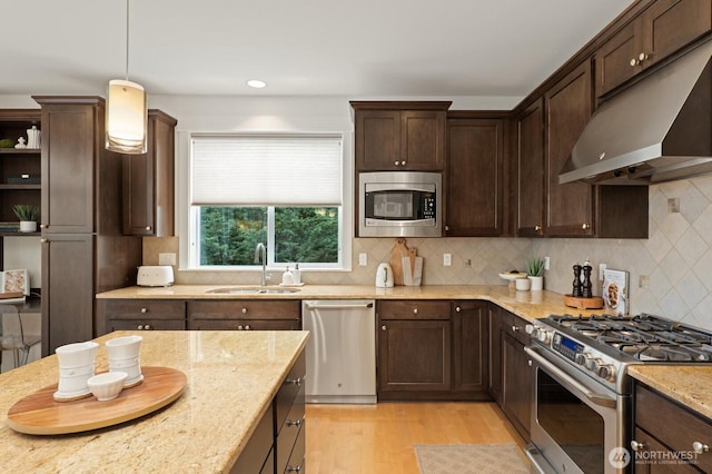 8829 138th Ct SE, Newcastle, WA 98059 - kitchen with stainless steel appliances, under cabinet range hood, dark brown cabinets, light wood finished floors, and light stone counters