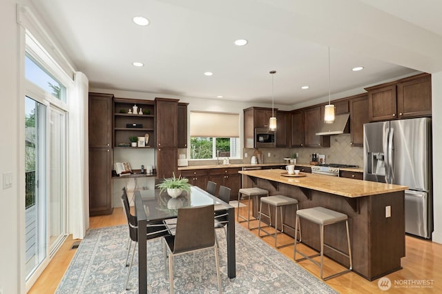 8829 138th Ct SE, Newcastle, WA 98059 - kitchen featuring stainless steel appliances, dark brown cabinetry, extractor fan, a center island, and decorative backsplash