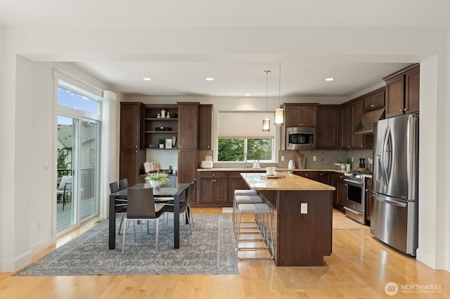 8829 138th Ct SE, Newcastle, WA 98059 - kitchen with stainless steel appliances, under cabinet range hood, dark brown cabinets, plenty of natural light, and recessed lighting
