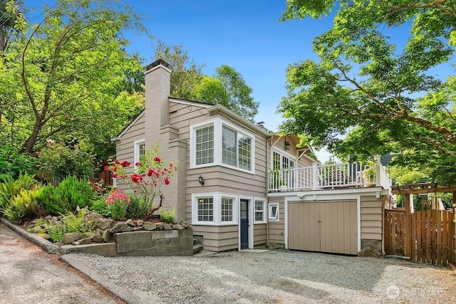 4431 SW Kenyon Pl, Seattle, WA 98136 - view of front of house with a chimney, a balcony, and driveway